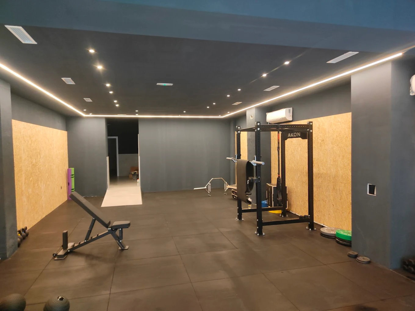 Sala principal VIMA — iluminación LED perimetral, rack AKON y suelo de goma profesional